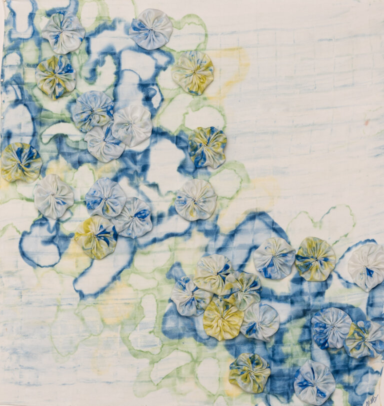 abstract mixed media piece in hues of blue, ochre and green