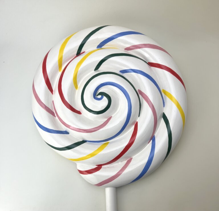 a ceramic sculpture of a large white lollipop striped in pink, red, lemon yellow, pine green, and french blue