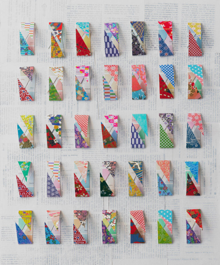 an abstract mixed media piece with 35 vertical rectangular scraps of multicolored paper evenly spaced in 5 rows of 7 on a pale book page collage