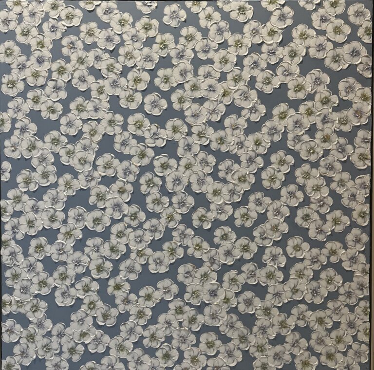 a mixed media piece on canvas of white flowers with blue and green centers scattered on a slate gray background