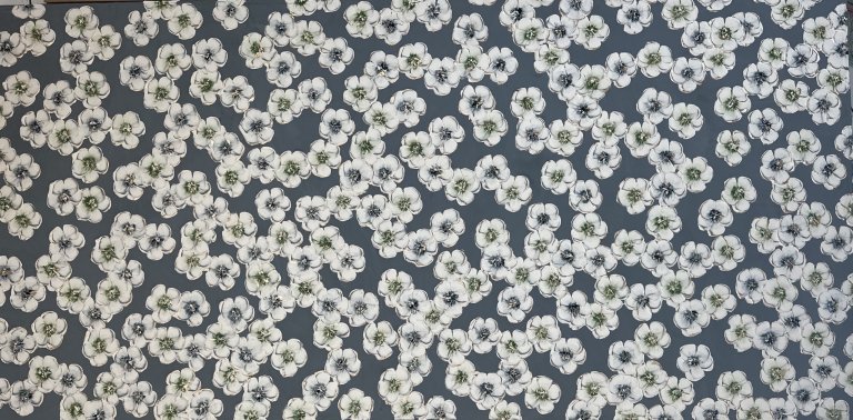 an abstract floral piece with a dark slate blue background. the foreground is a smattering of white blossoms. each flower has a dark green or an indigo center.