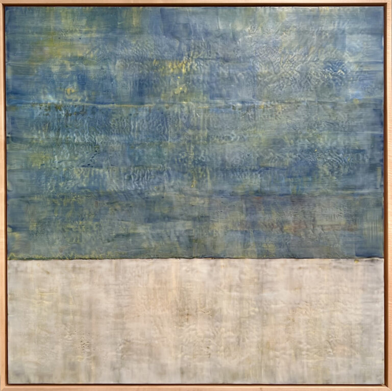 an abstract encaustic piece that is divided horizontally into two sections. the top section is a blue with olive accents, and the bottom is a cream color. where the two sections meet there is a thin black line