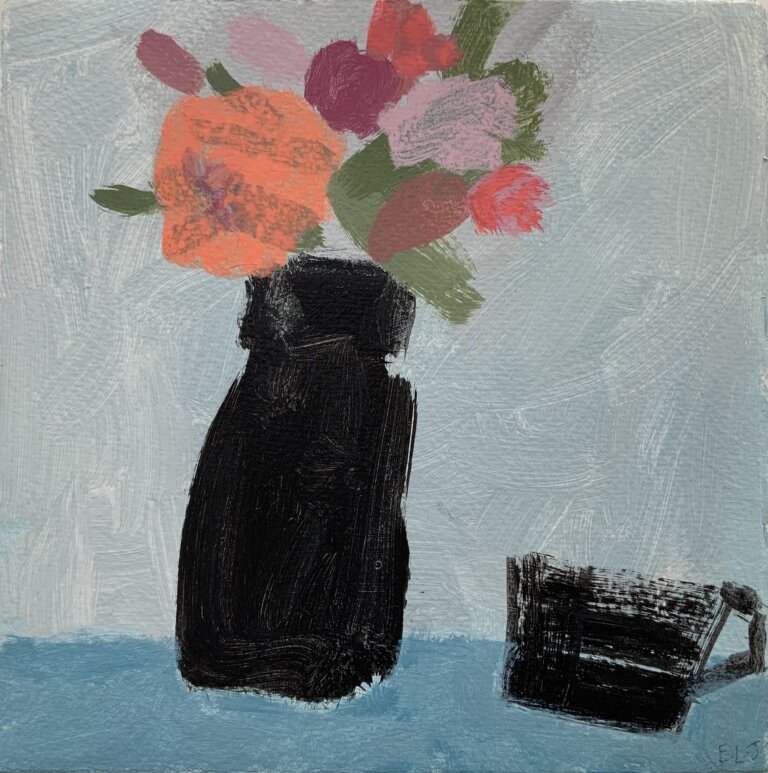 a simplified still life on a blue tablecloth on a table against a pale grey wall. on the table is a black jug filled with pink and orange flowers. there is a small black mug on the table to the right of the jug
