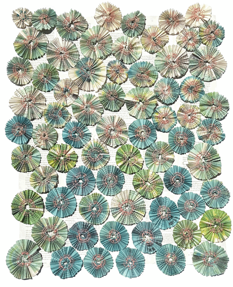 an abstract piece made up of accordion folded paper pinwheels in hues of seaglass green and blue. they are arranged in a roughly rectangular shape. the center of each pinwheel has coral drips in a circular shape