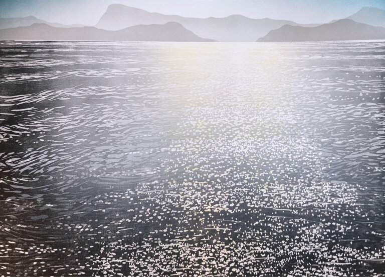 a landscape with a large body of water with mountains in the distance, the water has lots of waves and white speckles, giving the appearance of sunlight glancing off of it. there is a bright flash of light in the center of the piece created by a lightness in all the colors in that area. the sky above is a gradient of blue and white