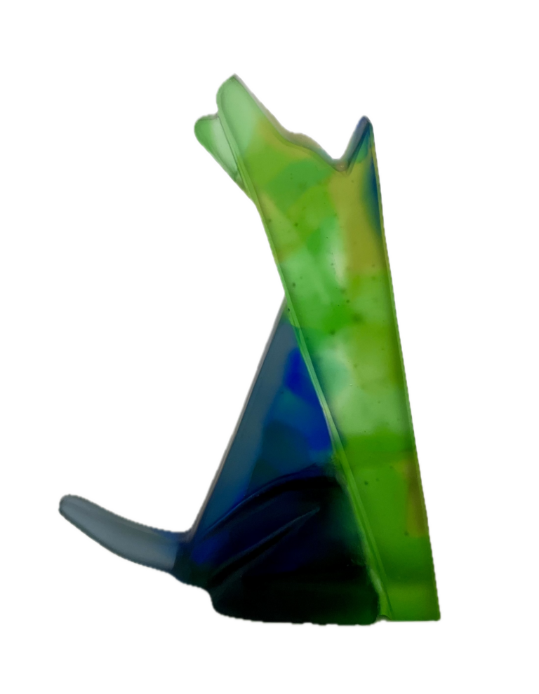 a hand cast green and blue glass interpretation of a seated howling wolf