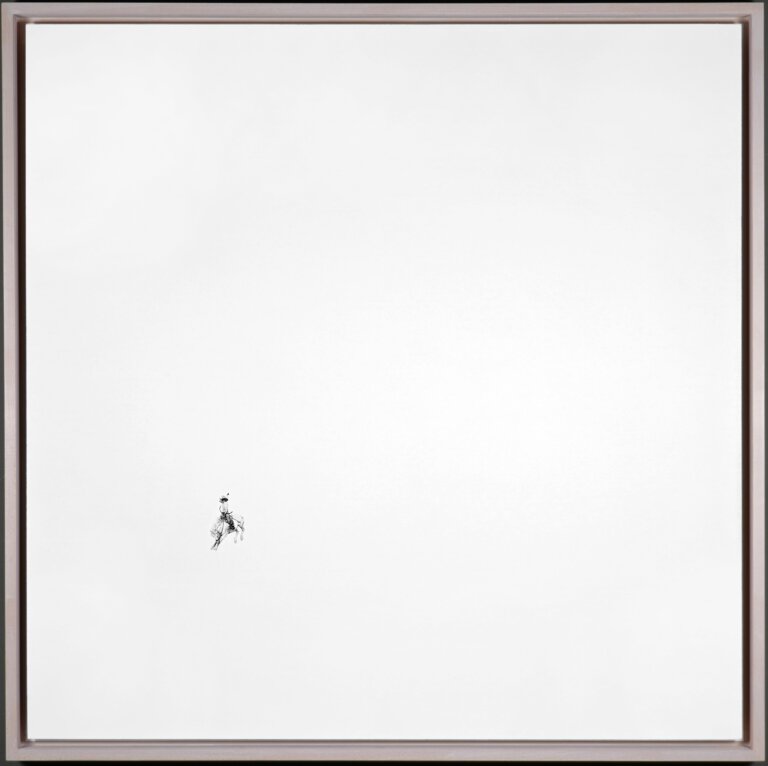 a highly detailed illustration of a rider on a bucking horse in motion drawn painstakingly in graphite in the left bottom of a large white panel board